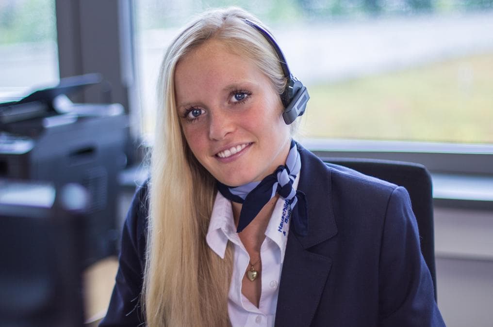 Mitarbeiterin des Empfangsdienstes mit Headset am Empfang